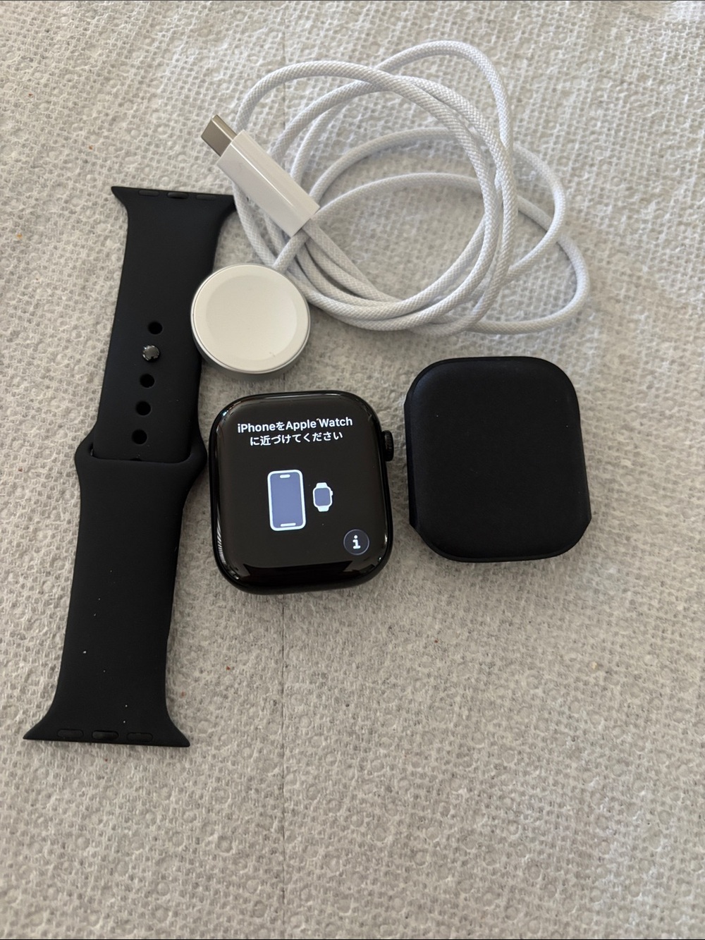 Apple Watch with Black Sport Band and White Charging Cable